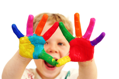 child holding up hands painted in many colors