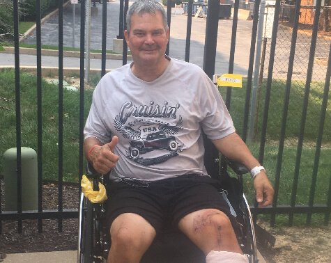 Man sitting in a wheelchair outside on a summer day.