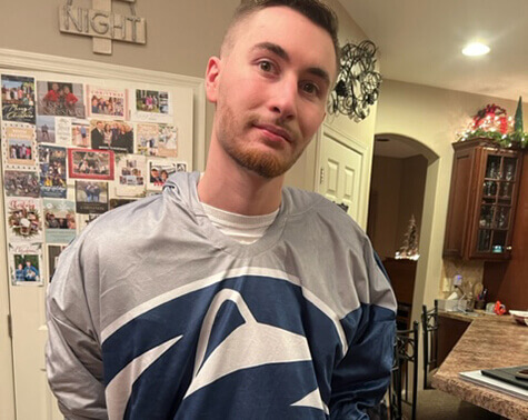 Jesse King showcasing his Penn State sweatshirt while posing for a photo.