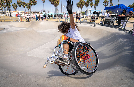 Tracie riding along the side of the bowl with one arm in the air